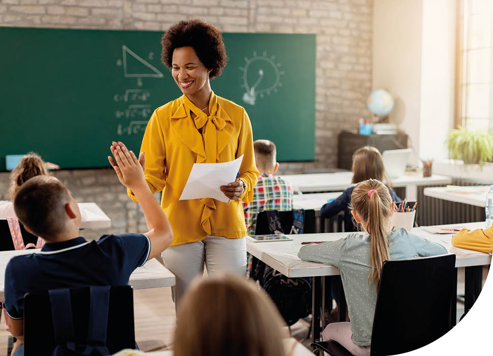 Happy African American teacher giving high-five to elementary student and congratulating him on good test results.